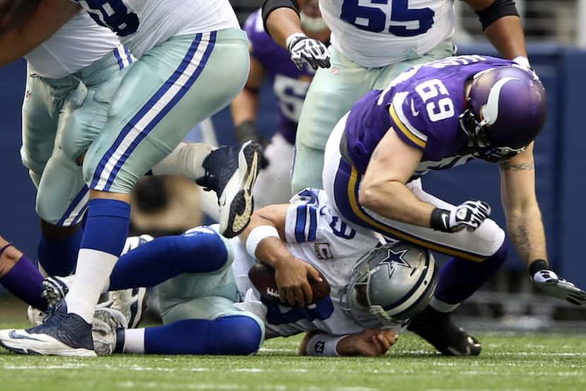 Dallas Cowboys quarterback Tony Romo (9) is sacked by Minnesota Vikings defensive end Jared...