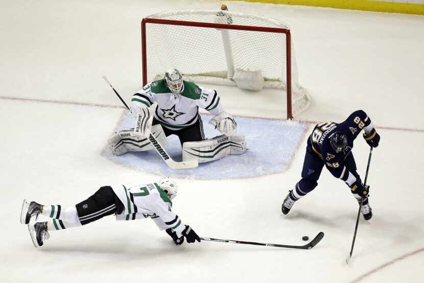 Dallas Stars' Johnny Oduya, bottom left, of Sweden, tries to clear a puck away from St....