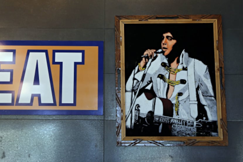 An Elvis poster shares a wall with another sign at a Raising Cane's  in West Plano.