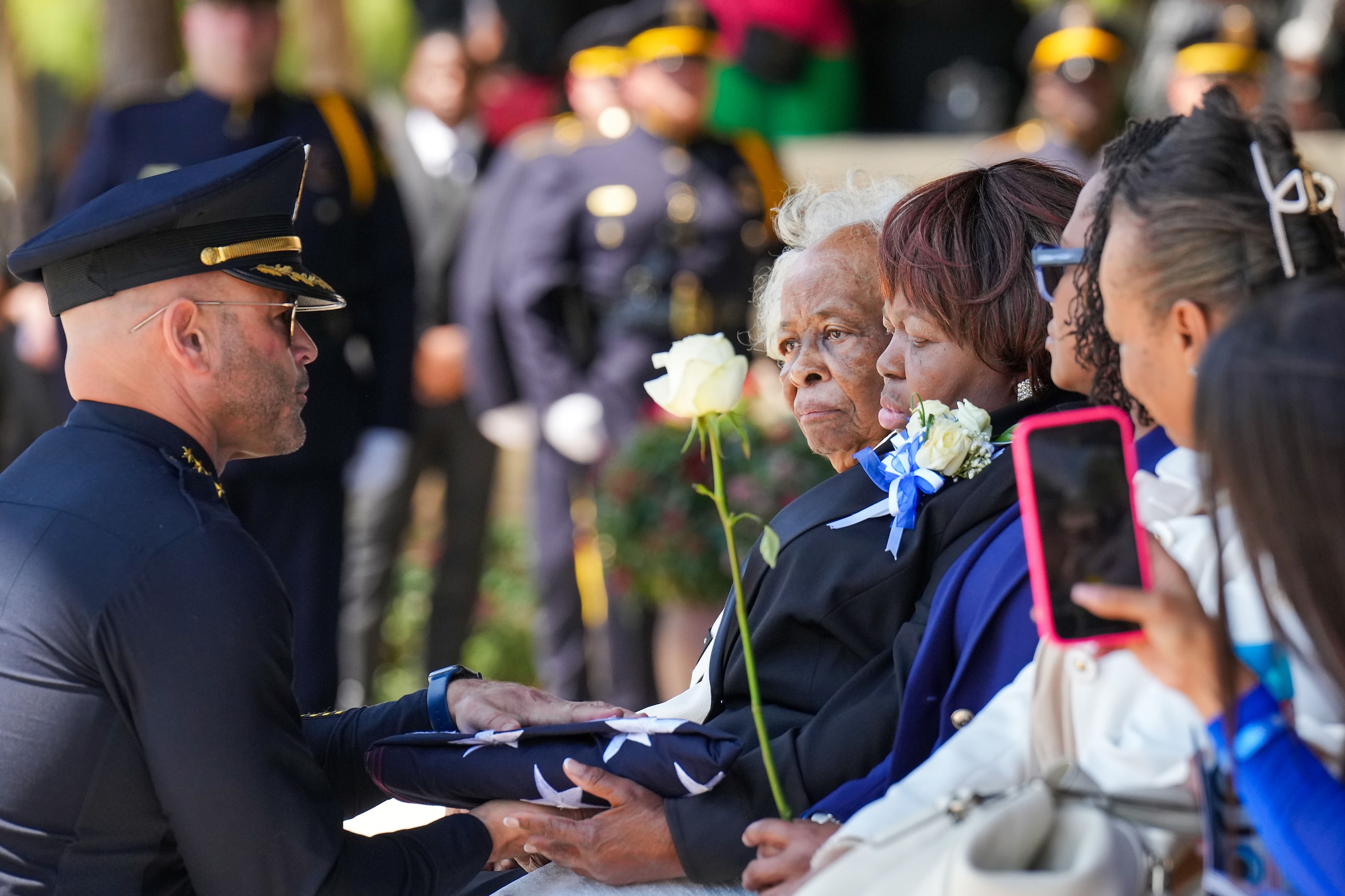 Dallas Police Chief Eddie García presents the folded flag from the casket of officer Darron...