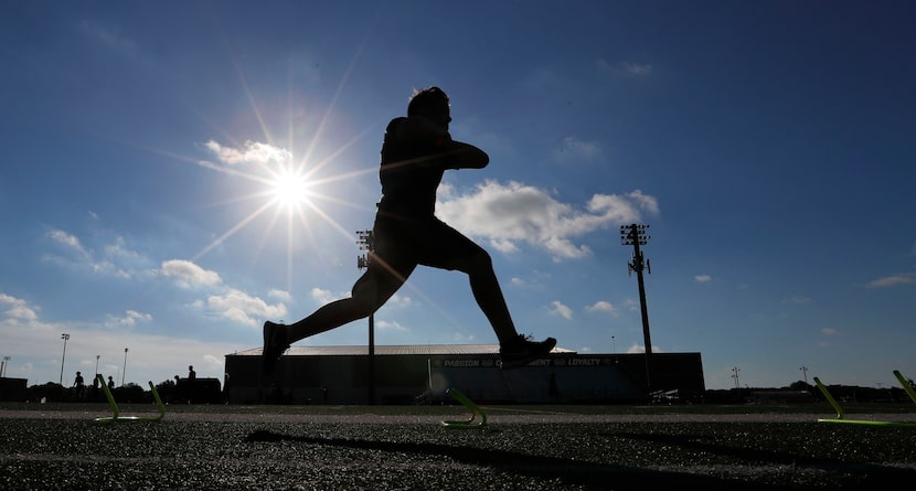 A student athlete runs a drill during a strength and conditioning camp at Arlington Martin...