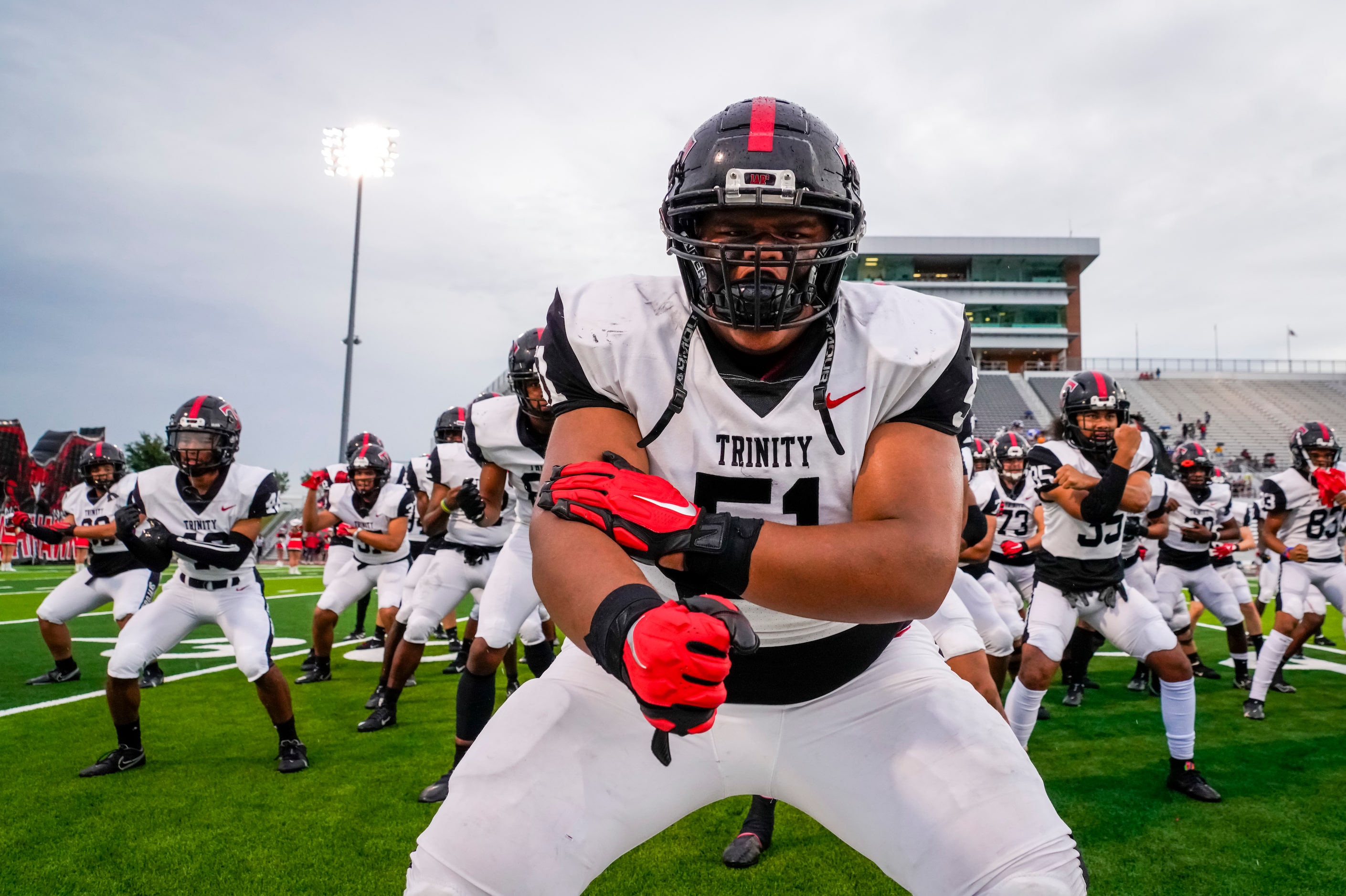 Euless Trinity offensive lineman Peni Masima (51) leads teammates as they do the  Sipi Tau...