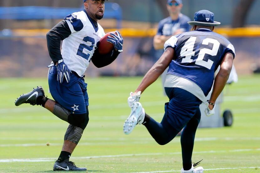 Dallas Cowboys rookie running back Ezekiel Elliott (21) carries the ball as he is covered by...