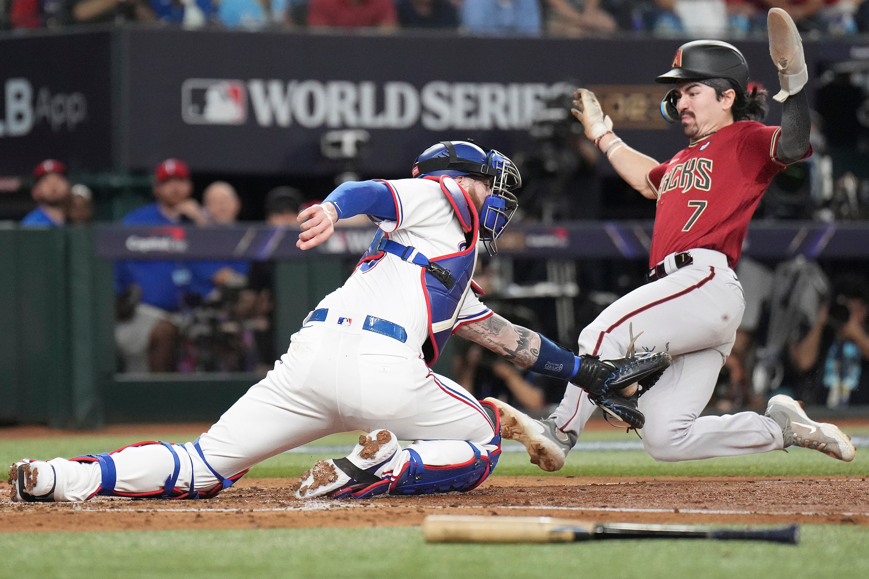 Arizona Diamondbacks' Corbin Carroll scores past Texas Rangers catcher Jonah Heim during the...