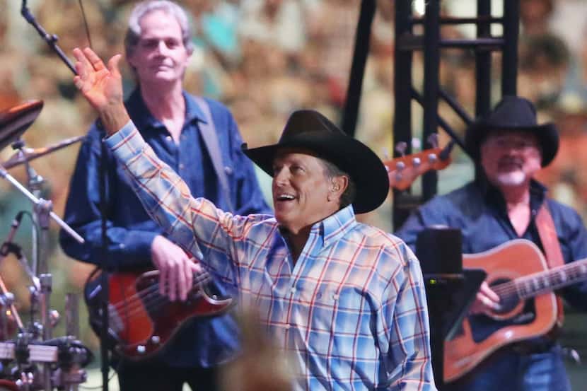 George Strait waves to the crowd as he plays the last show of his final tour at AT&T Stadium...
