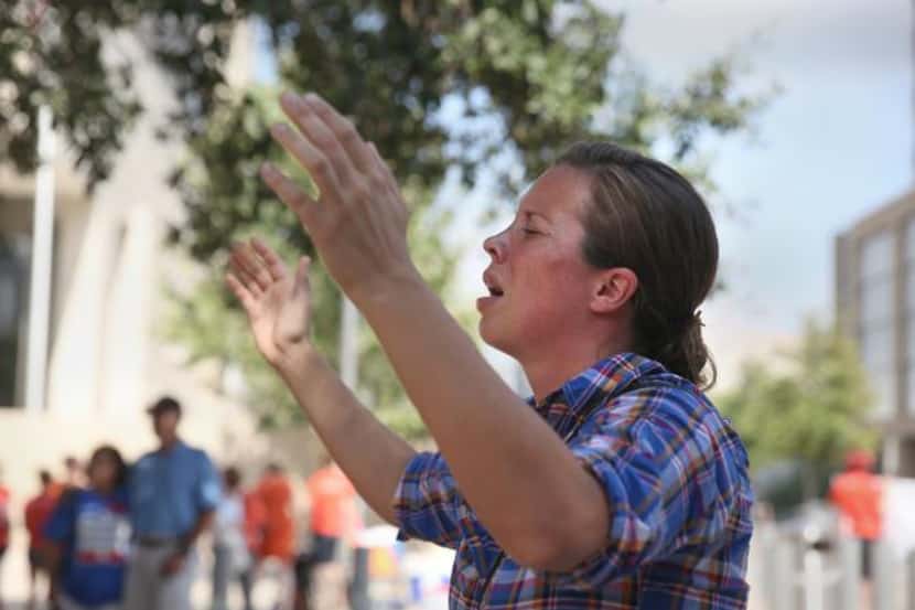 
Sara Holland prays to “lift up the name of Jesus,” near the federal courthouse in Austin. 


