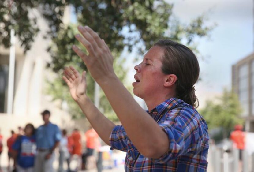 
Sara Holland prays to “lift up the name of Jesus,” near the federal courthouse in Austin. 


