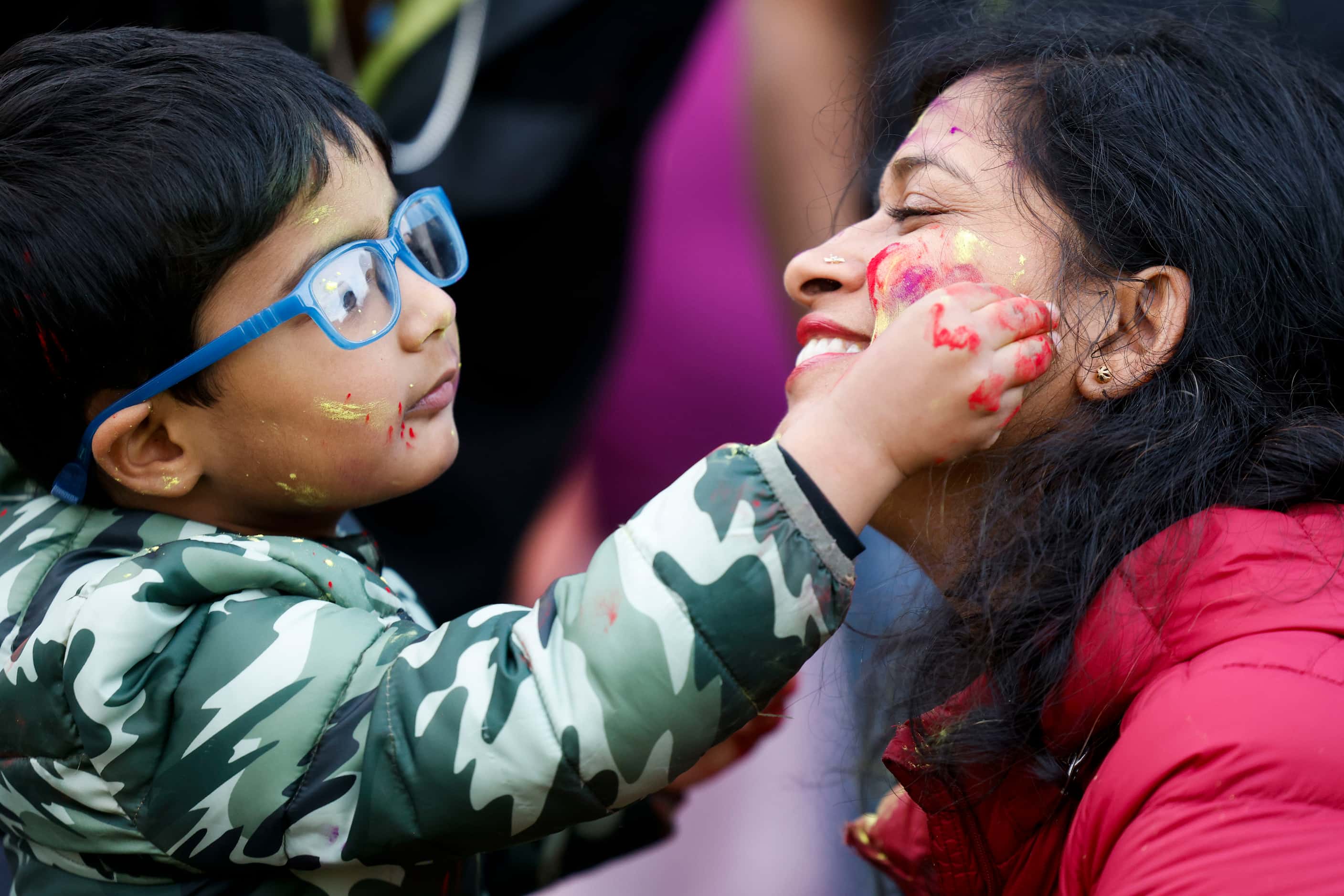 Ayaan Agarwal, 4, (left), applies color on his aunt, Rashmi Gupta during Holika Dahan, a...