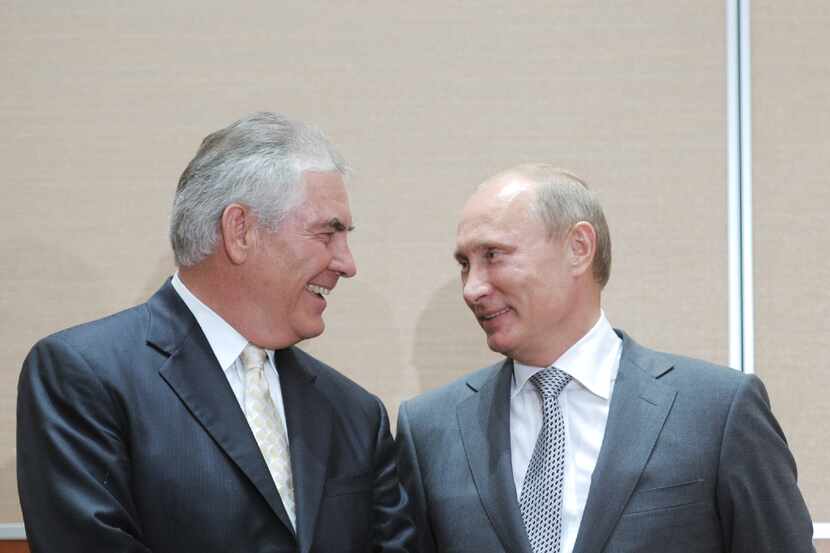 Russia's Prime Minister Vladimir Putin, right, speaks with Exxon Mobil President and CEO Rex...