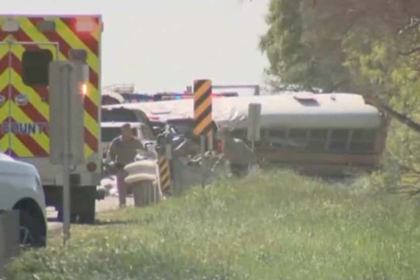 First responders work the scene of a deadly crash after a school bus carrying...