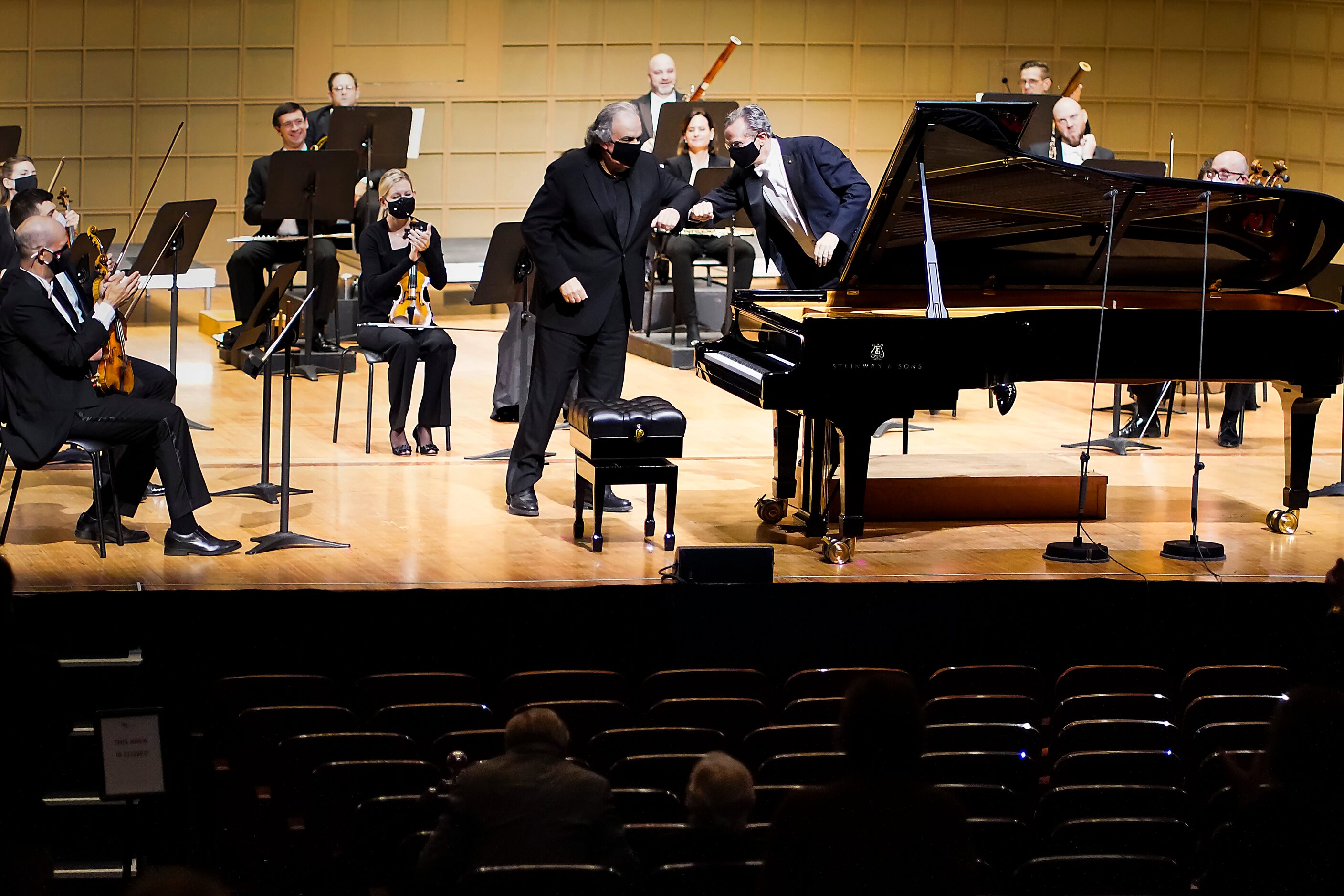 Music director Fabio Luisi (right) elbow bumps with pianist Yefim Bronfman during the...