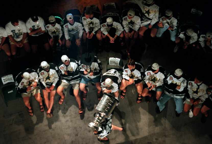 Stars players cheer as Eddie Belfour parades the Stnaley Cup on the stage at the victory...