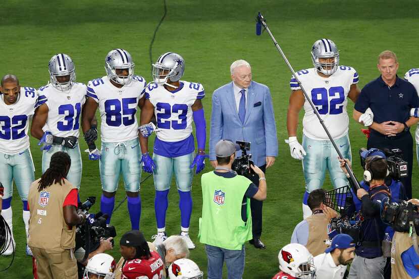 Dallas Cowboys owner and general manager Jerry Jones waits for the team to link arms before...