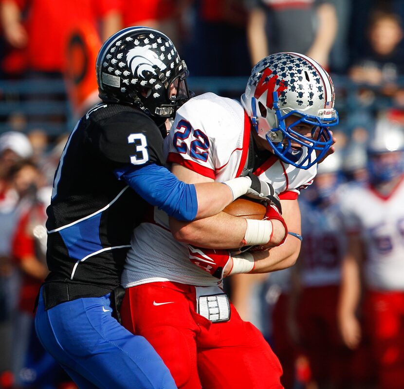 Austin Westlake's Chris Canter (22) is tackled by Plano West's Collin Eberle (3) in the...