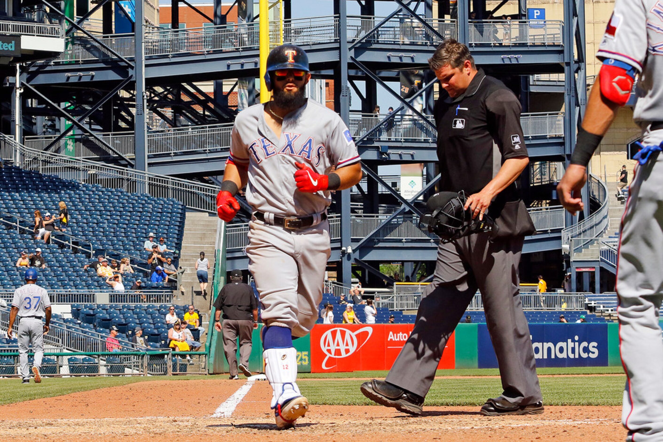 Rougned Odor (12) of the Texas Rangers touches home after hitting a home run in the ninth...