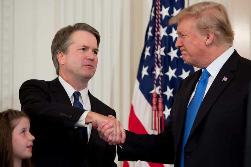 Judge Brett Kavanaugh shakes hands with President Donald Trump on Monday after Trump...