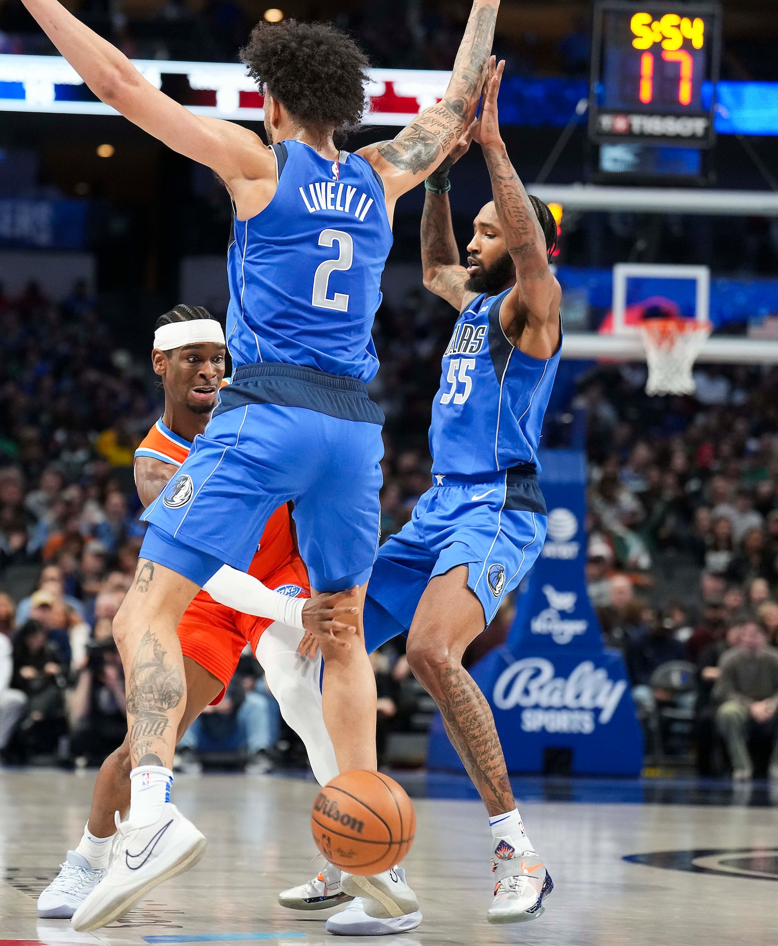 Oklahoma City Thunder guard Luguentz Dort (5) passes through the legs of Dallas Mavericks...