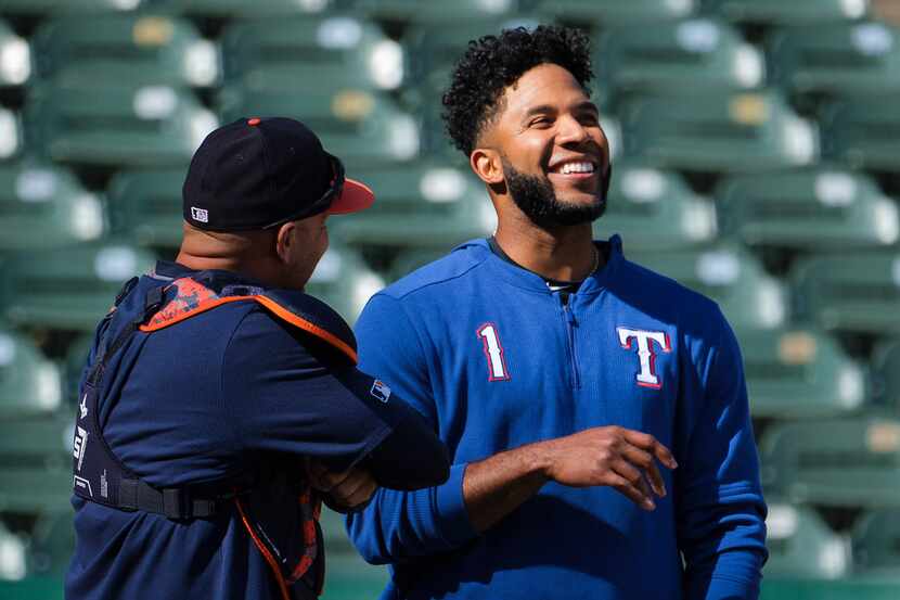 Texas Rangers shortstop Elvis Andrus laughs with Houston Astros bullpen catcher Javier...