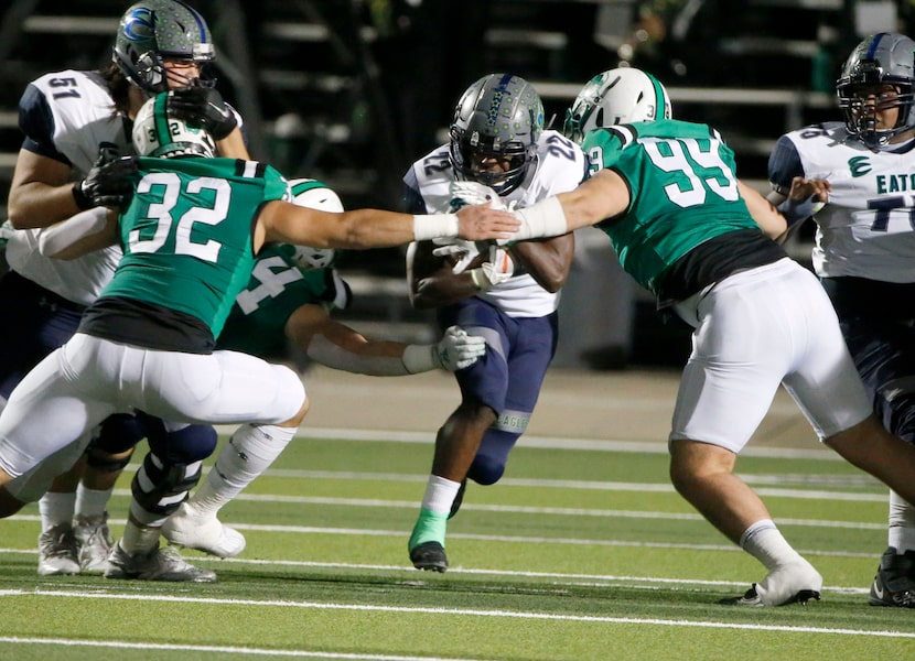 Southlake defenders Benecio Porras (32) and Andrew Askew (99) prepare to tackle Eaton...