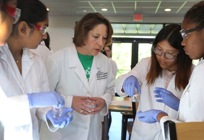 Northeast Texas Girl Scouts CEO Jennifer K. Bartkowski (center) watches as high school-age...