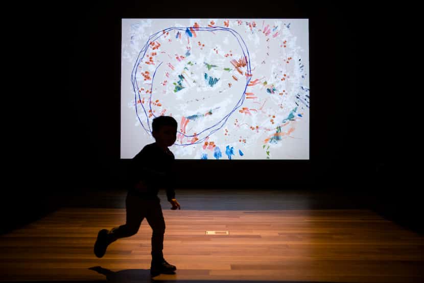 Ashton Morgan, 4, runs in circles in an interactive art exhibit on the second floor of the...