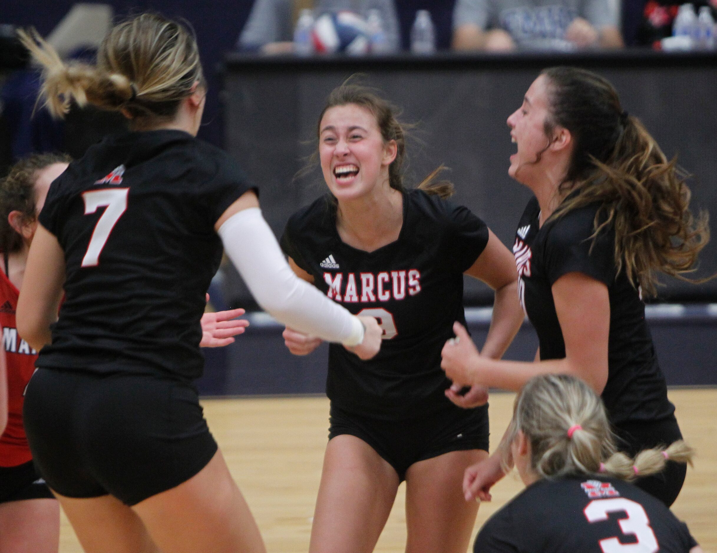 Flower Mound Marcus' Maggie Cox (9), center, celebrates her 3rd set sealing shot with...