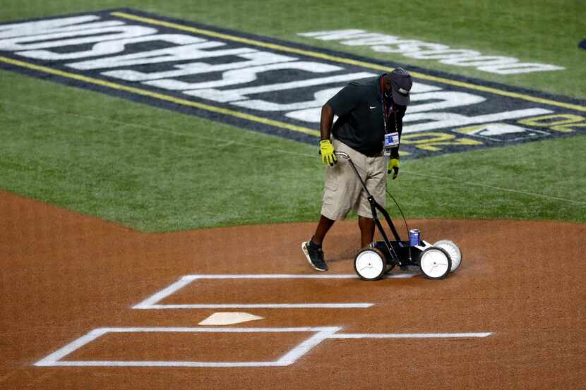 A groundskeeper paints the home plate box before the Los Angeles Dodgers-San Diego Padres...