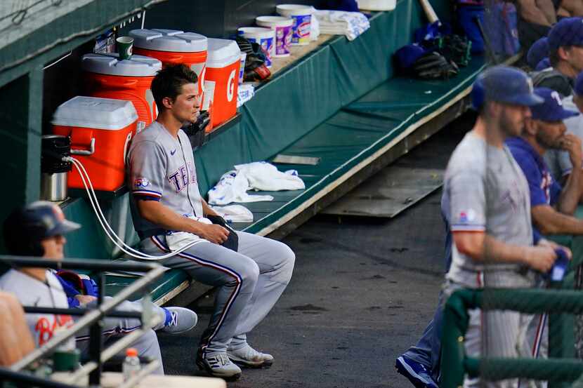 Texas Rangers' Corey Seager sits in the dugout during the second inning of a baseball game...