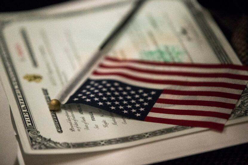 An American flag rests on a certificate of citizenship during a naturalization ceremony in...