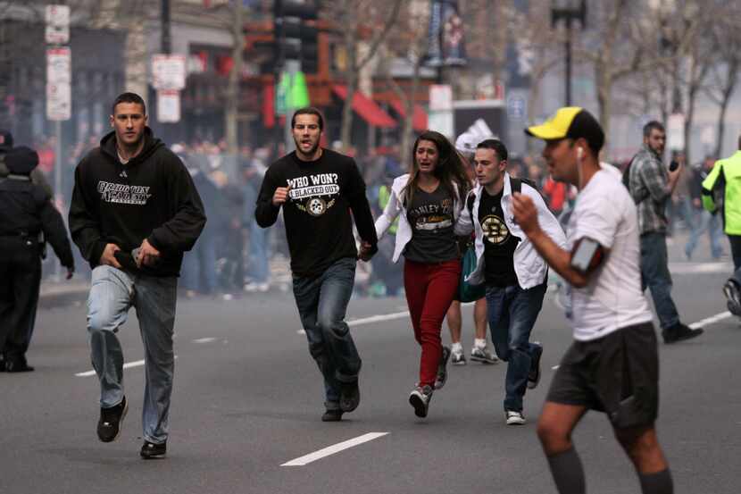 Runners and spectators fled the scene after two explosions rocked the Boston Marathon on...