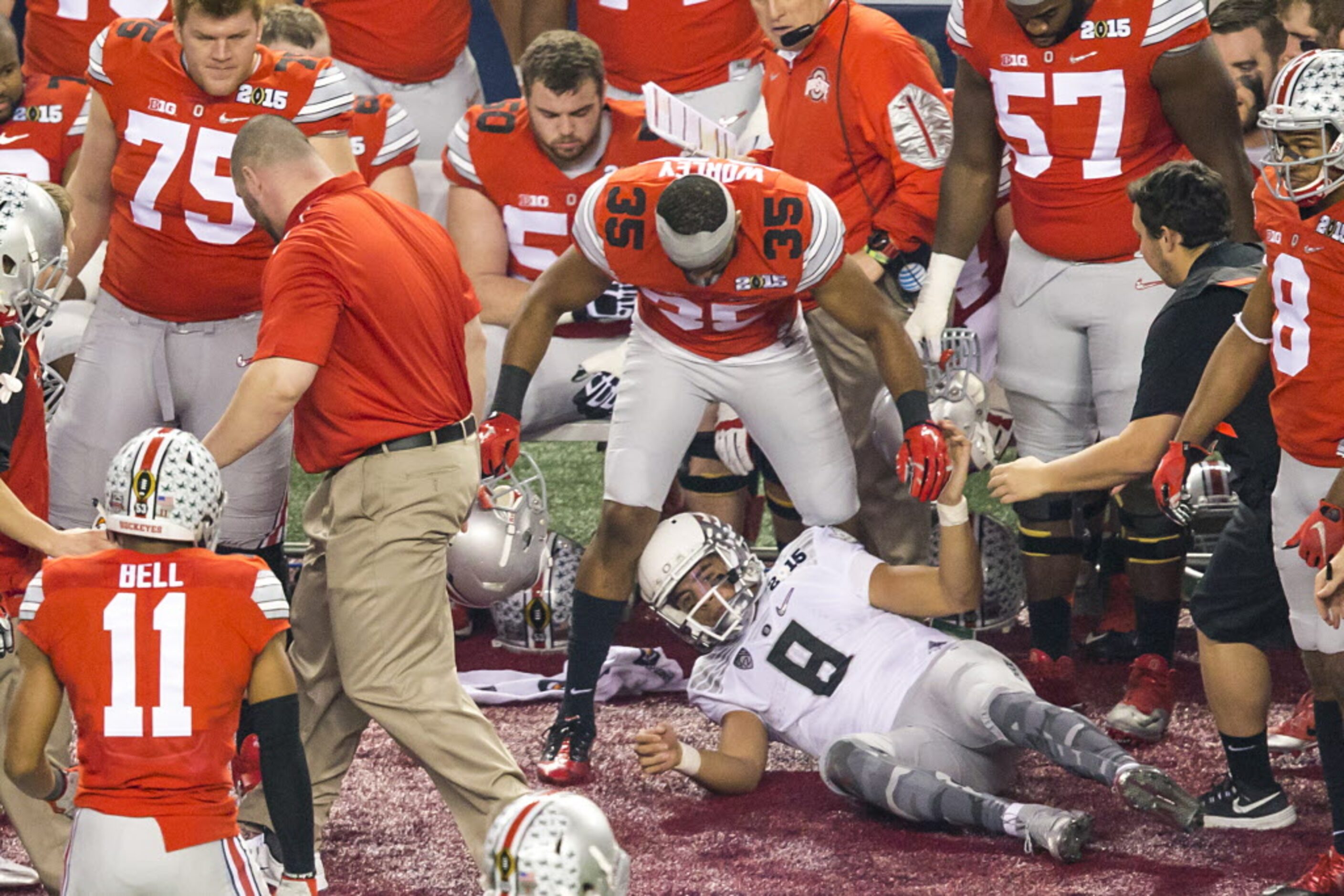 Oregon Ducks quarterback Marcus Mariota (8) slides into the Ohio State Buckeyes bench after...