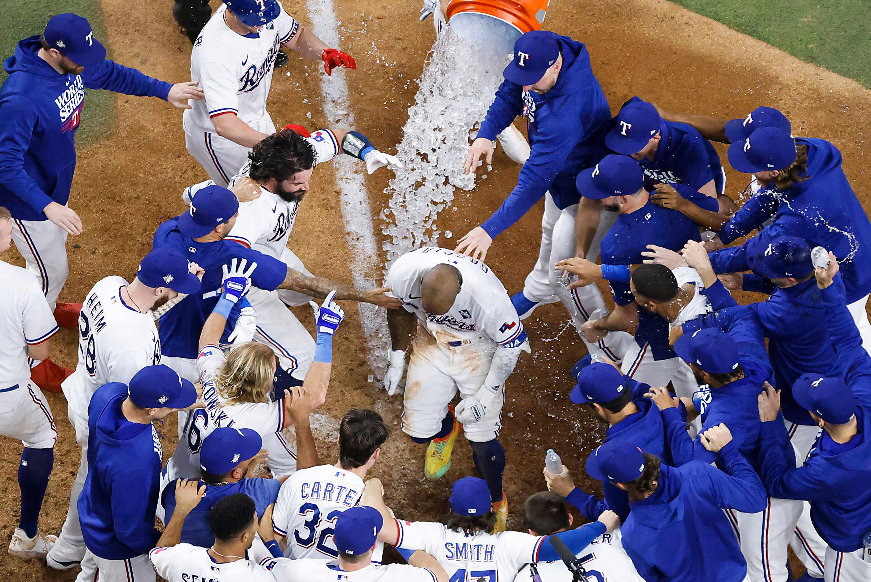 Texas Rangers right fielder Adolis Garcia is mobbed at home plate after hitting a walk-off...
