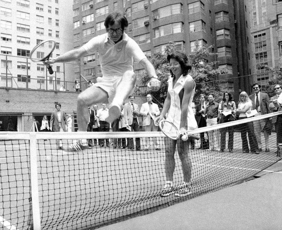 Wimbledon Champ Billie Jean King holds down the net as Bobby Riggs, the 55-year-old tennis...