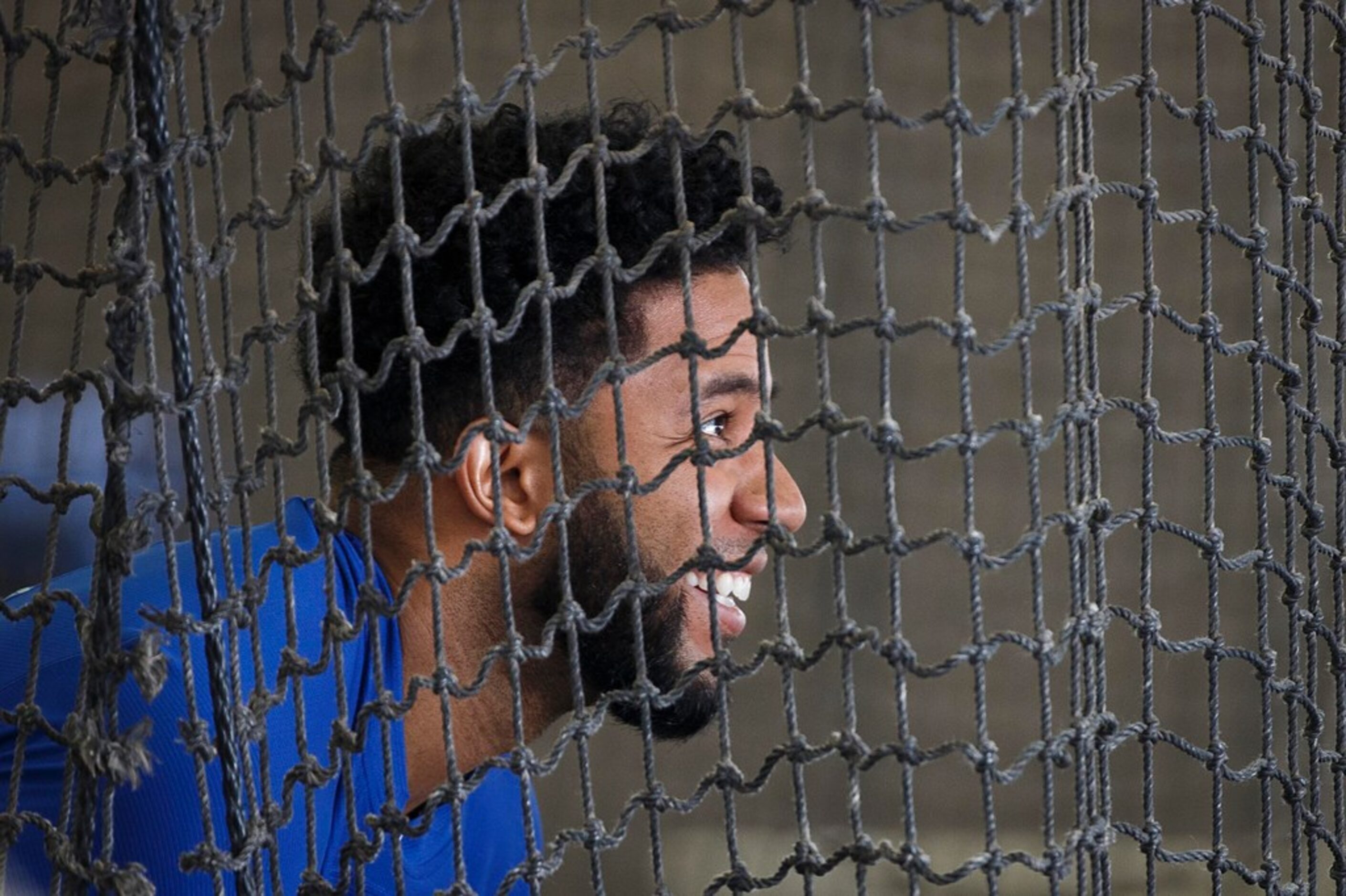 Texas Rangers shortstop Elvis Andrus laughs with teammates in the batting cages during a...