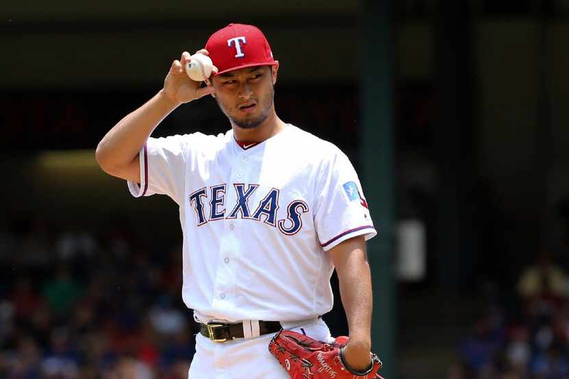 FILE - In this July 9, 2017, file photo, Texas Rangers starting pitcher Yu Darvish adjusts...