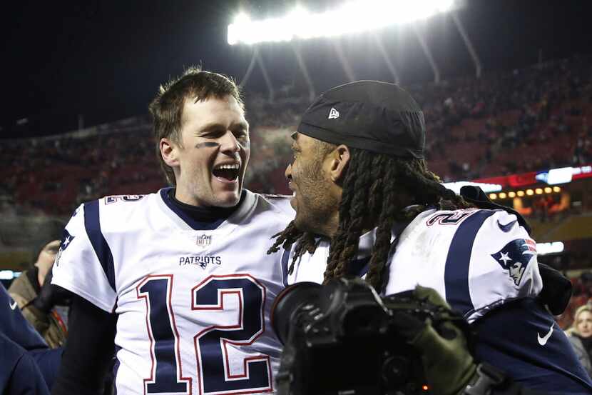 New England Patriots quarterback Tom Brady (12) celebrates with cornerback Stephon Gilmore...