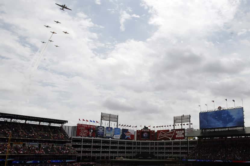 Vintage planes from the Cavanaugh Flight Museum fly over Globe Life Park before an opening...