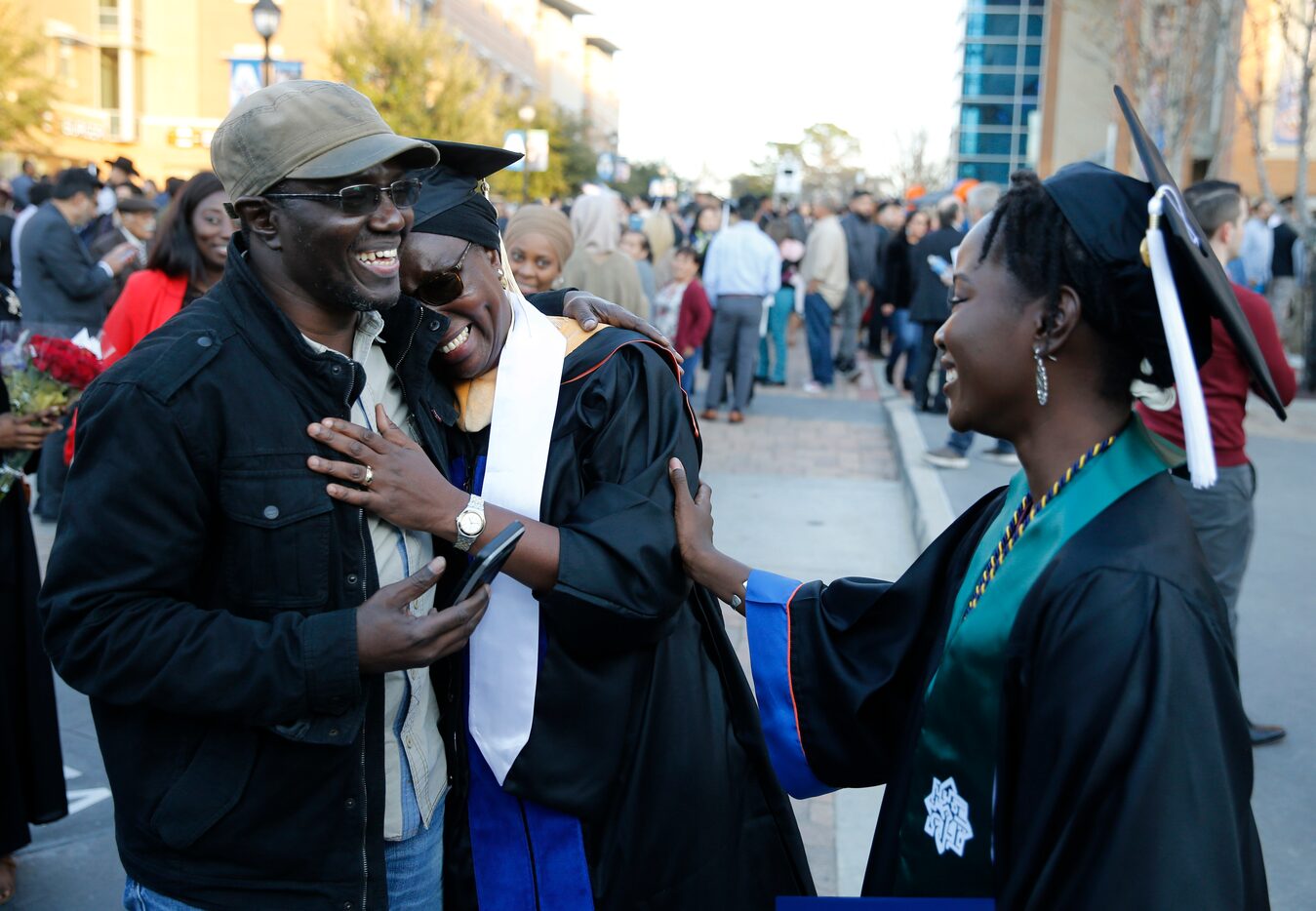 Cheikh Sy hugs his wife Ndeye Ndaw as they share a laugh with their daughter Awa Sy outside...