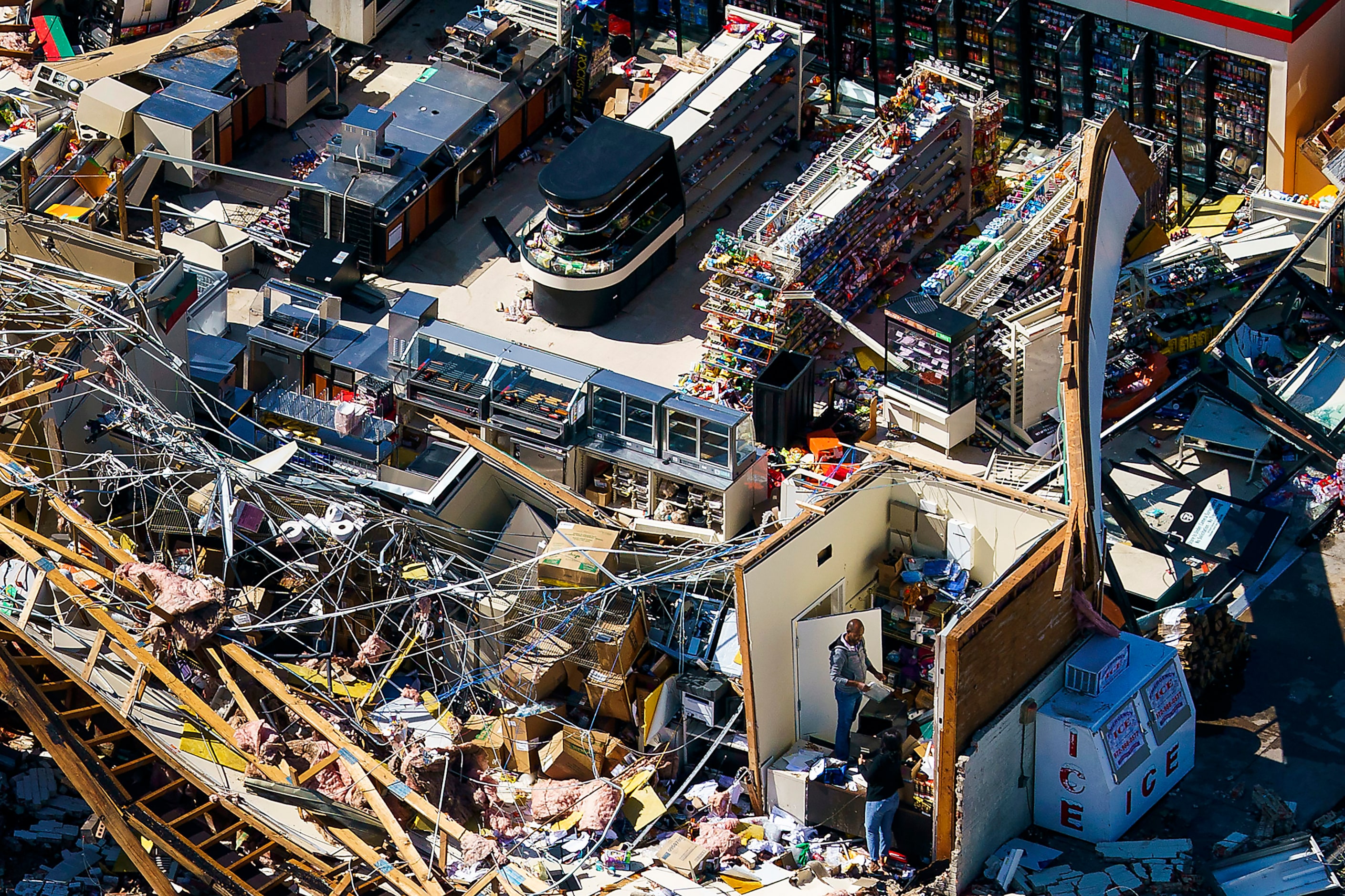 People pick through the rubble of a 7-Eleven store on Walnut Hill near Harry Hines on...