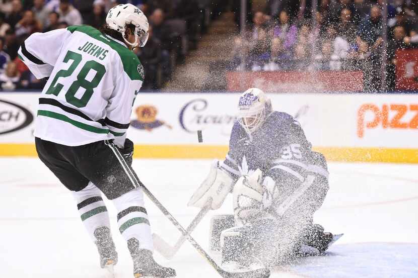 Toronto Maple Leafs goalie Curtis McElhinney (35) gets sprayed with snow as he makes a save...