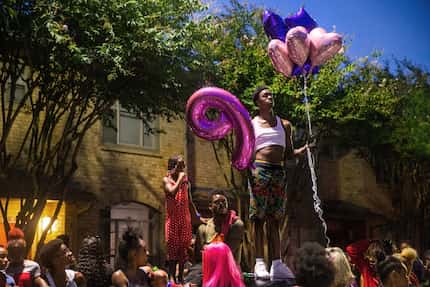 Dayday Elder holds balloons while standing above family and friends gathered to honor the...