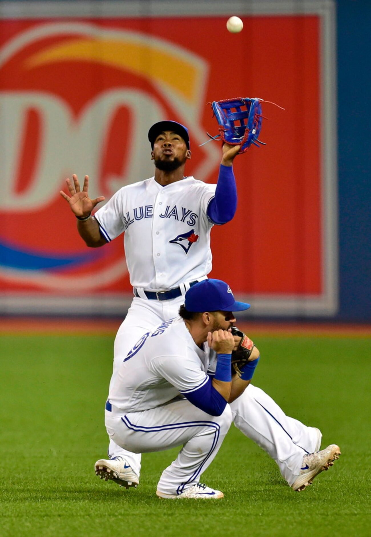 Toronto Blue Jays' Teoscar Hernandez (37) and Devon Travis (29) almost collide with each...