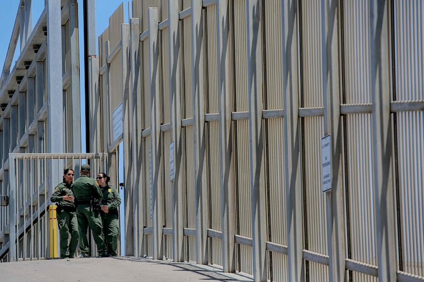 US Customs and Border Protection agents patrol the United States-Mexico Border wall at...