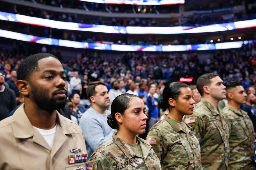 Veterans and members of the armed forces fill court-side seats for an NBA game between the...