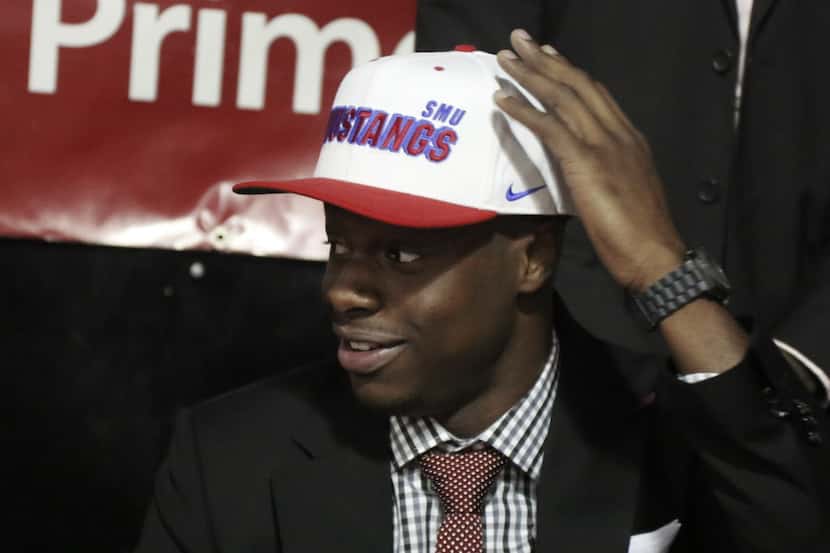 Prime Prep boys basketball player Emmanuel Mudiay tries on a hat after signing to play...