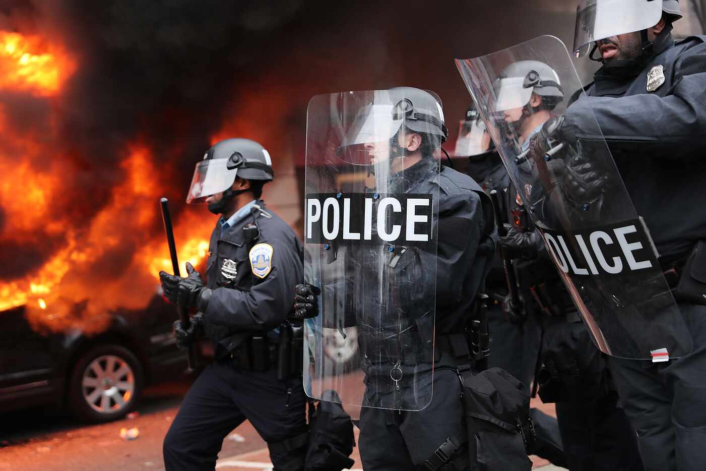 Police and demonstrators clash in downtown Washington after a limo was set on fire following...