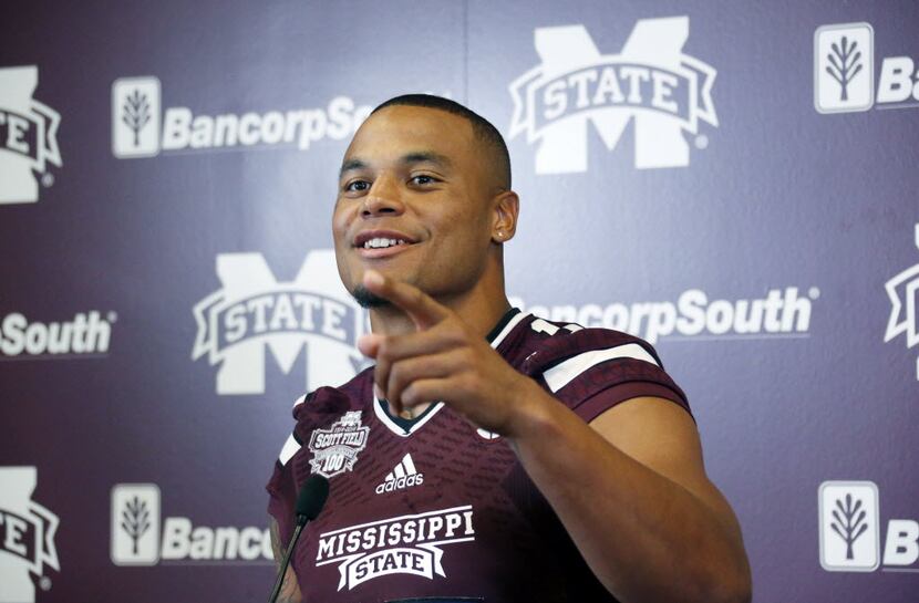 Mississippi State quarterback Dak Prescott smiles at a question from reporters about the...