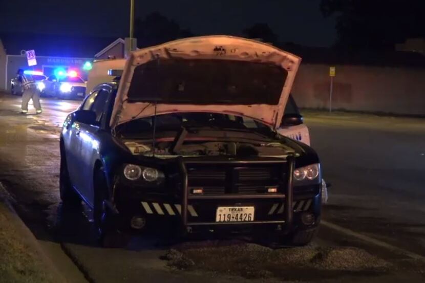 A Dallas police squad car damaged by a collision with a large rock sat along Hampton Road on...