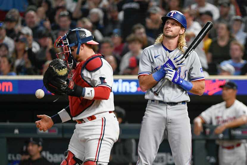 Texas Rangers' Travis Jankowski, right, reacts after striking out as Minnesota Twins catcher...