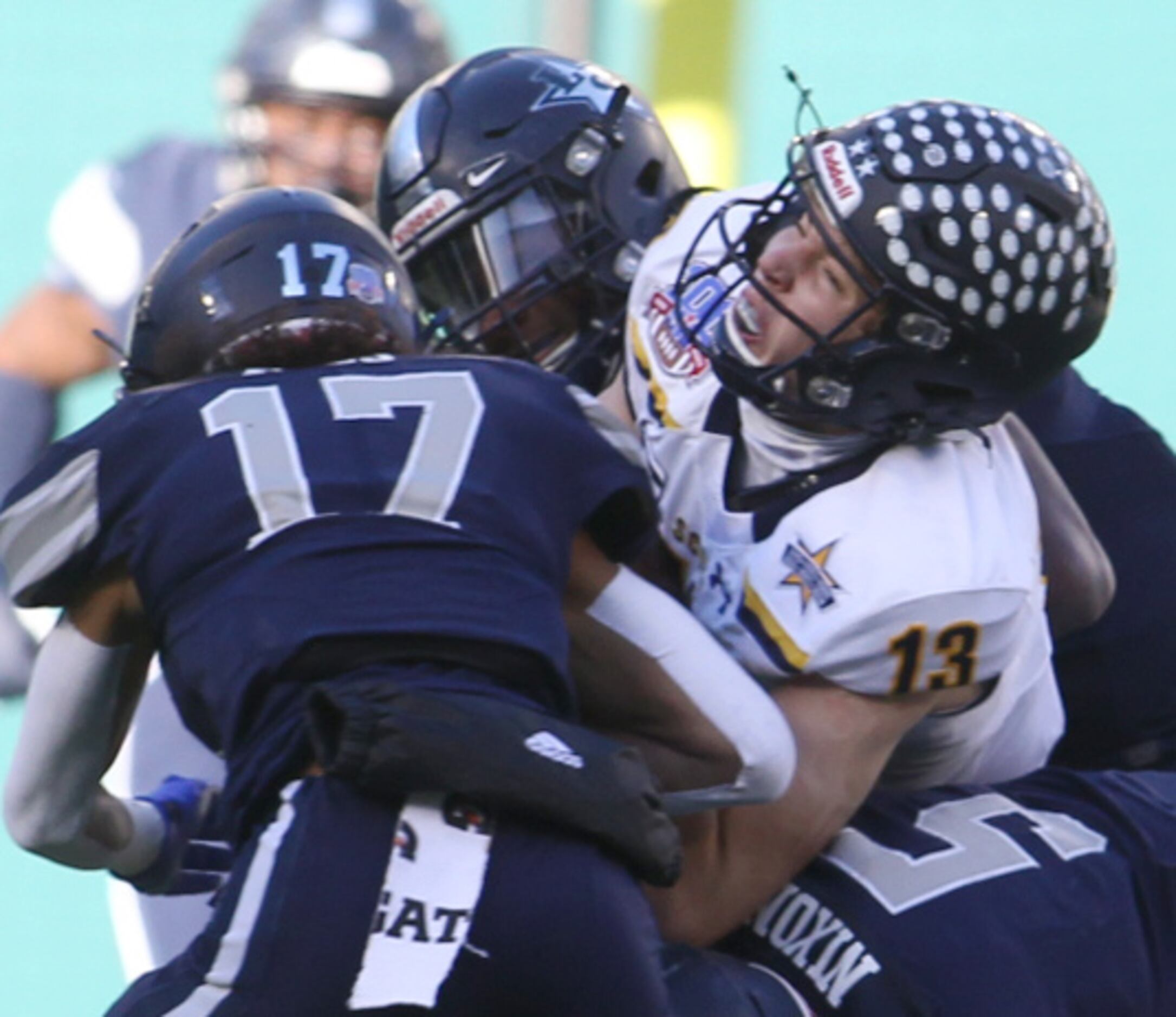 Highland Park quarterback Brayden Schager (13) winces as he is sandwiched by Frisco Lone...